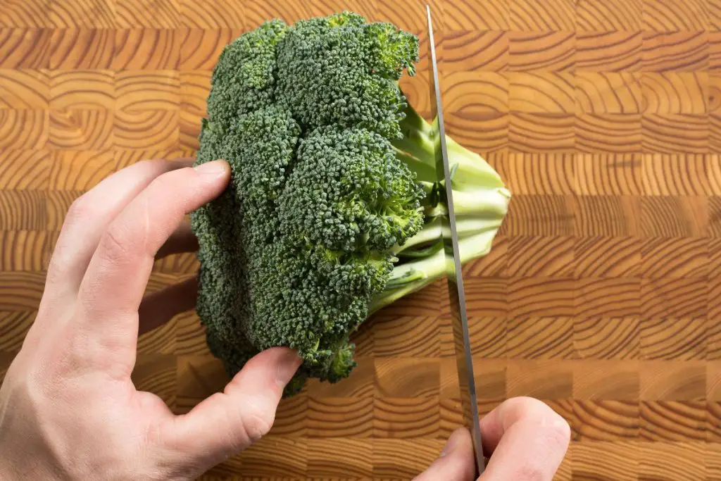 Can Chickens Eat Broccoli? 3 cutting broccoli on chopping board