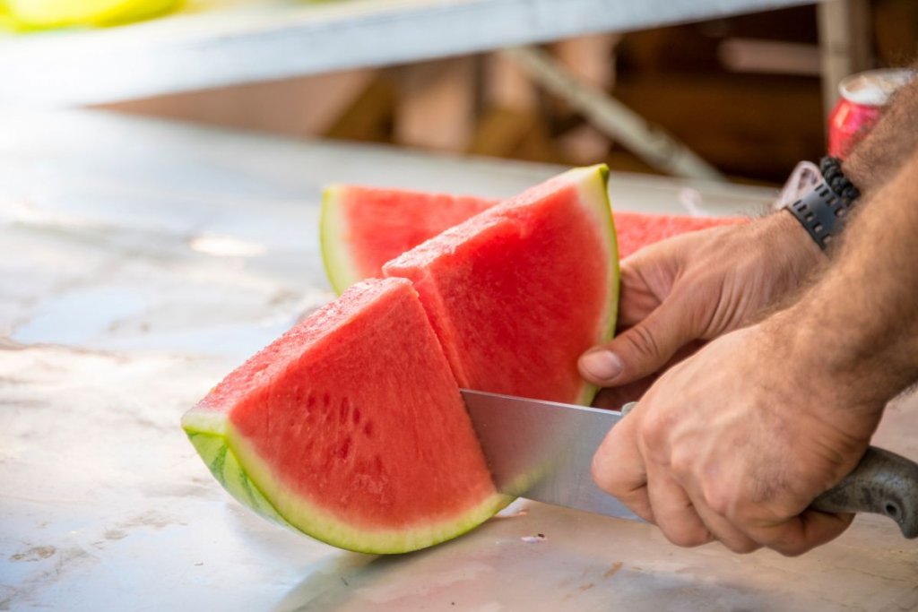 man cutting watermelon
